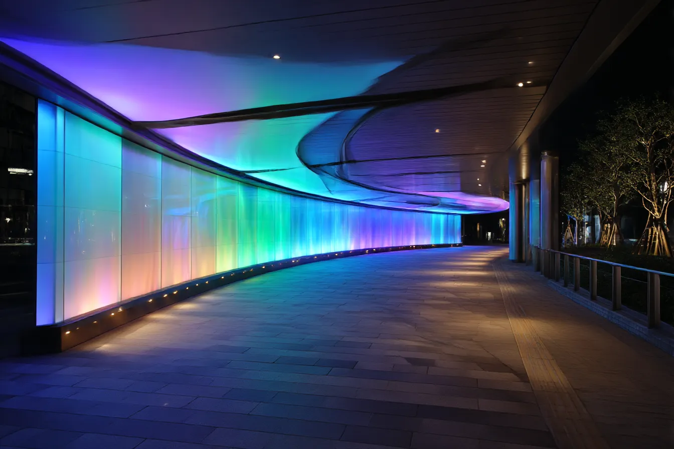 光のアートと都会的なおしゃれ背景｜虹色に輝く光のアートが壁を飾る都会的な空間。夜の都会のエネルギーを感じさせる美しい光が「おしゃれ背景」を作り出しており、洗練された印象を与えます。都会のモダンな雰囲気が感じられます。