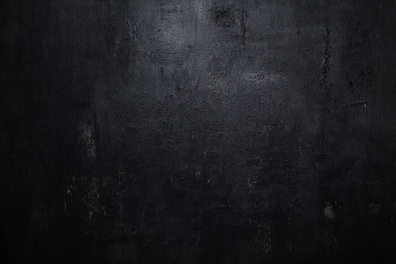 黒い背景でテクスチャーのある壁｜深い黒色のテクスチャーが感じられる背景。荒削りな壁面に金色の点が少しだけ残り、洗練されたシンプルさの中に独特な存在感が漂う。黒い背景がシンプルでありながらも重厚感を与えている。