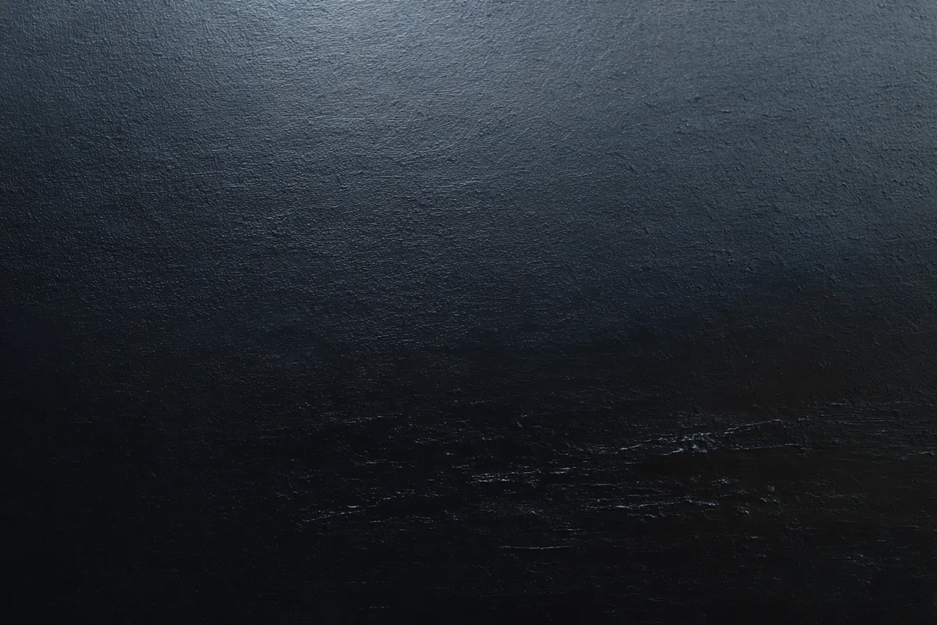 黒い背景でシンプルな質感の壁面｜シンプルで無駄のない黒い背景が強調された一枚。わずかな光の反射が、上質で洗練された雰囲気を醸し出し、シックな空間を作り出す。「黒」の背景が与える力強い印象が際立っている。
