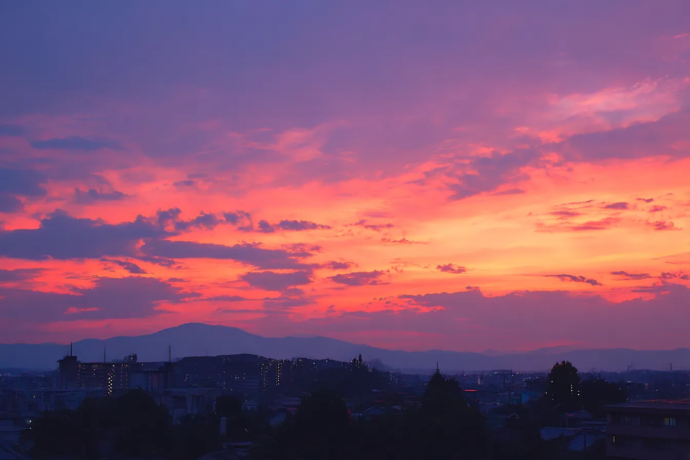 夕焼け空の街並みのエモい背景｜鮮やかなオレンジと紫が溶け合う空に、静かに広がる都市のシルエット。日常の終わりと始まりを感じさせる、郷愁と希望が入り混じったようなエモさが漂います。