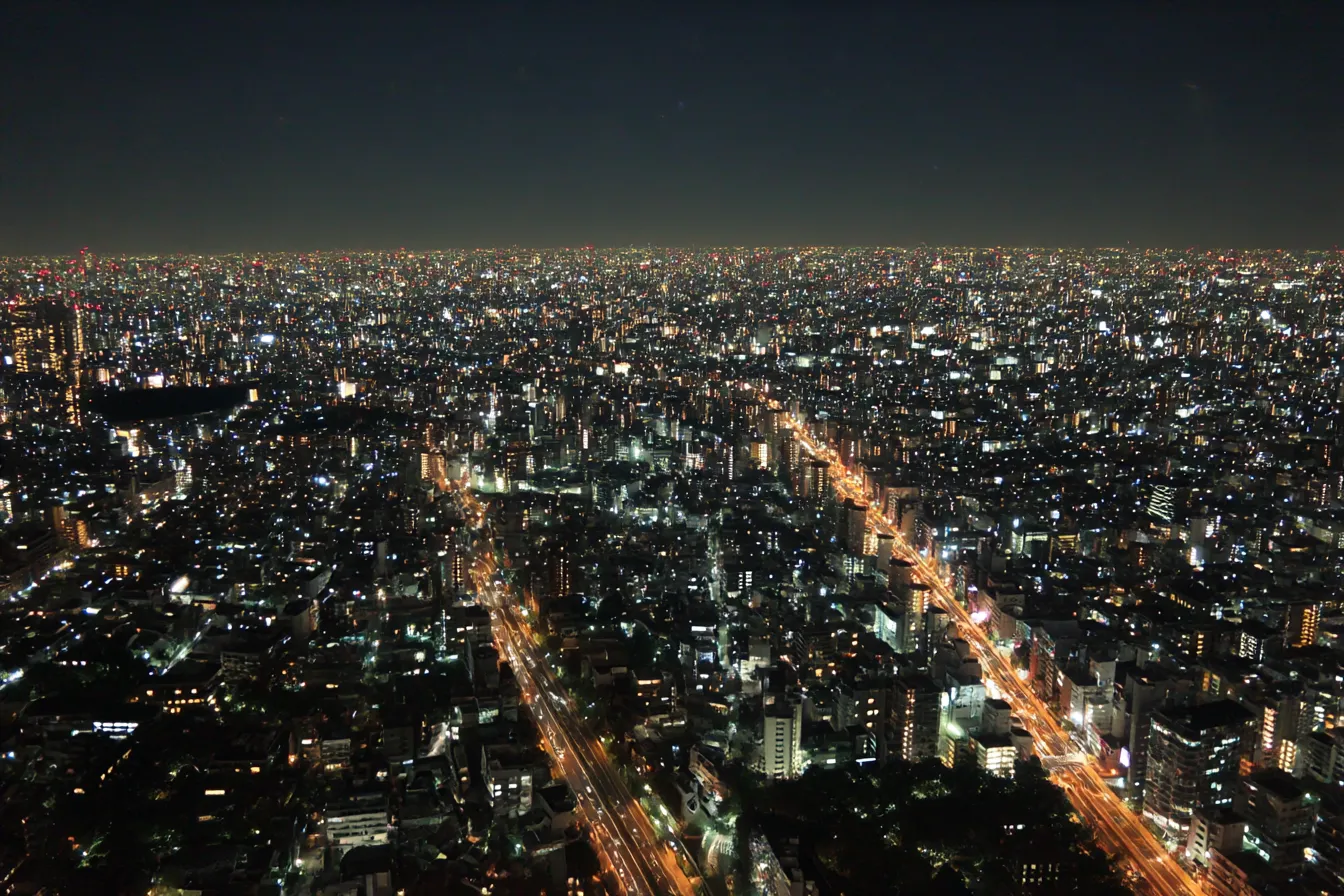 夜景背景×都市の光の海｜果てしなく広がる都市の灯りが夜空と溶け合うように輝く俯瞰構図。圧倒的スケール感とSF的な未来都市の雰囲気が魅力の背景です。