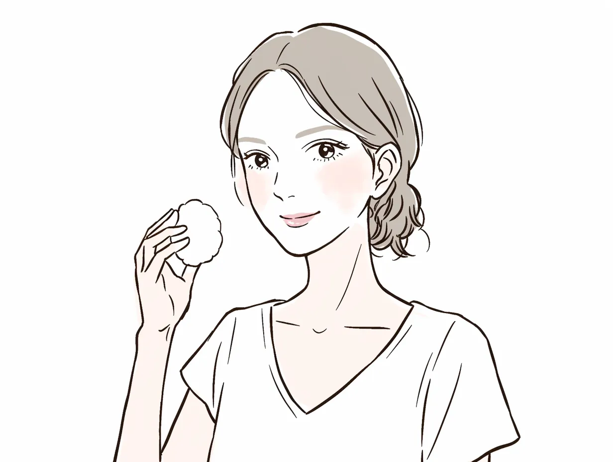 化粧水とコットンの清潔感｜コットンを軽く持つ女性の仕草に、化粧水を使った爽やかさが表現されている。髪をまとめたシンプルな姿と明るい色彩が、清潔感と落ち着いた雰囲気を同時に伝えている。