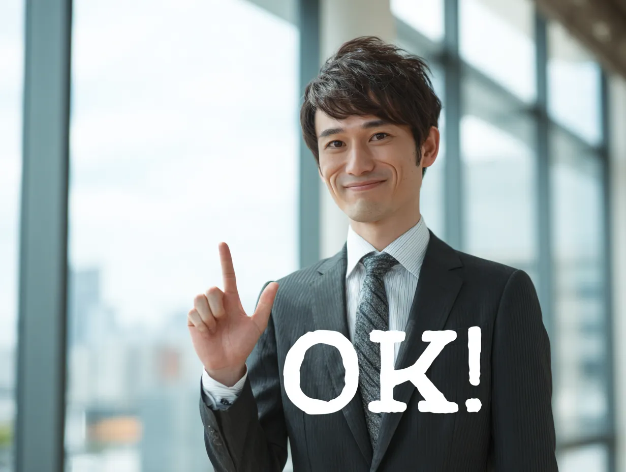 OKで納得感ある表情を演出｜スーツ姿の男性が微笑みながらOKを示し、背景の窓の奥行きが爽やかな雰囲気をプラス。納得や合意を象徴する表現として活用しやすい一枚です。