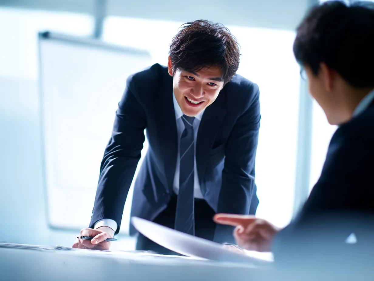 仕事の説明をしながらデータを示すシーン｜スライドを使ってデータを説明しているシーンです。明るく親しみやすい表情で、視覚的に情報を伝えているため、聴衆に安心感と信頼感を与えます。データに基づくプレゼンテーションでの利用に最適な素材です。