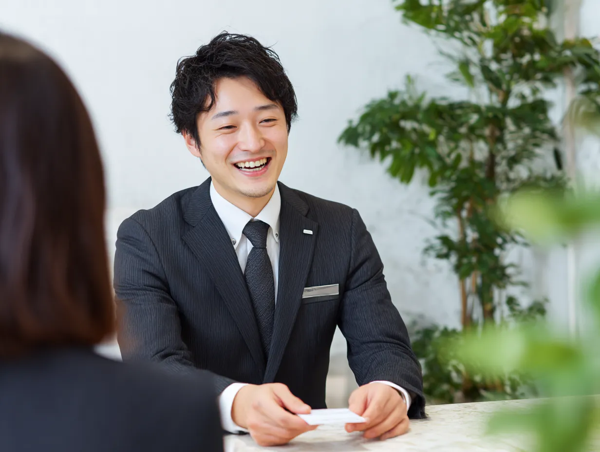 名刺を差し出す男性スタッフの紹介｜丁寧な表情で名刺を渡す男性ビジネスマンの姿が印象的。自己「紹介」や商談のはじまりを表すビジネスシーンに最適な構図。