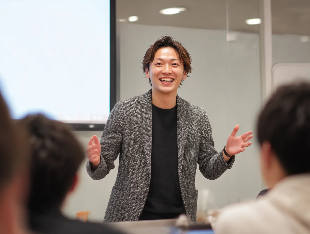 プレゼン中に話す講師の笑顔の話す｜受講者に向けてプレゼンする男性講師が明るく「話す」場面。わかりやすく伝える姿勢を強調した、教育やビジネス研修に最適な素材。