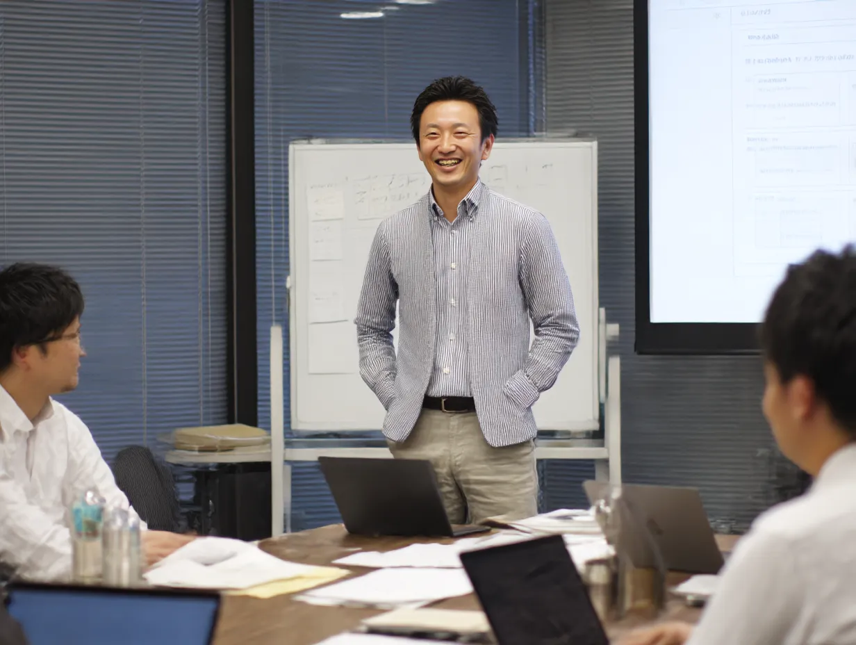 会議を引き締める若手課長｜カジュアルシャツで登場する課長が会議をリードするシーン。親しみやすさとリーダーシップの両立を感じさせる現代的な素材です。