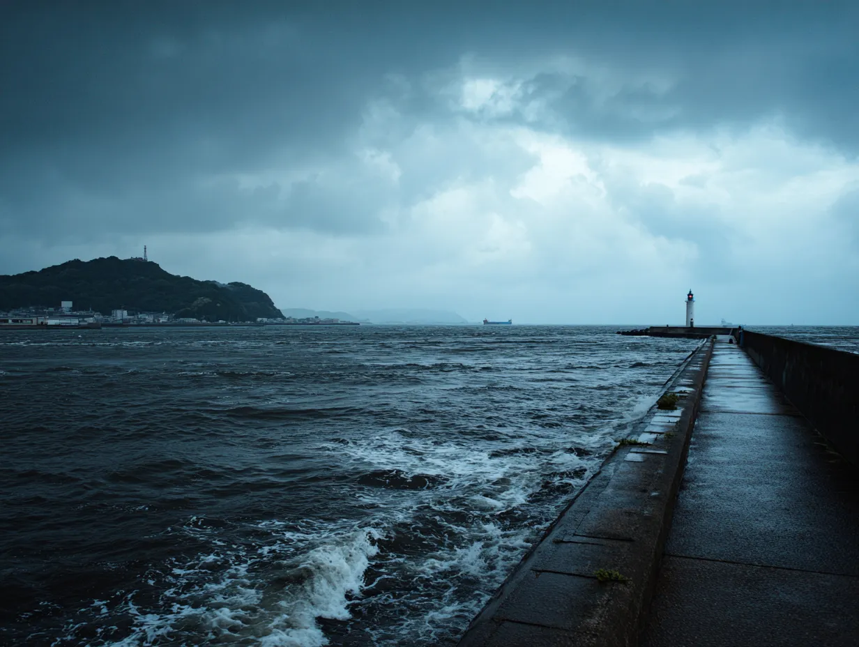 灯台と海のエモい風景｜暗い雲と荒波の中に伸びる防波堤と灯台が印象的で、孤独感や力強さを感じさせます。エモい風景として観光や文学的なビジュアルに利用可能です。