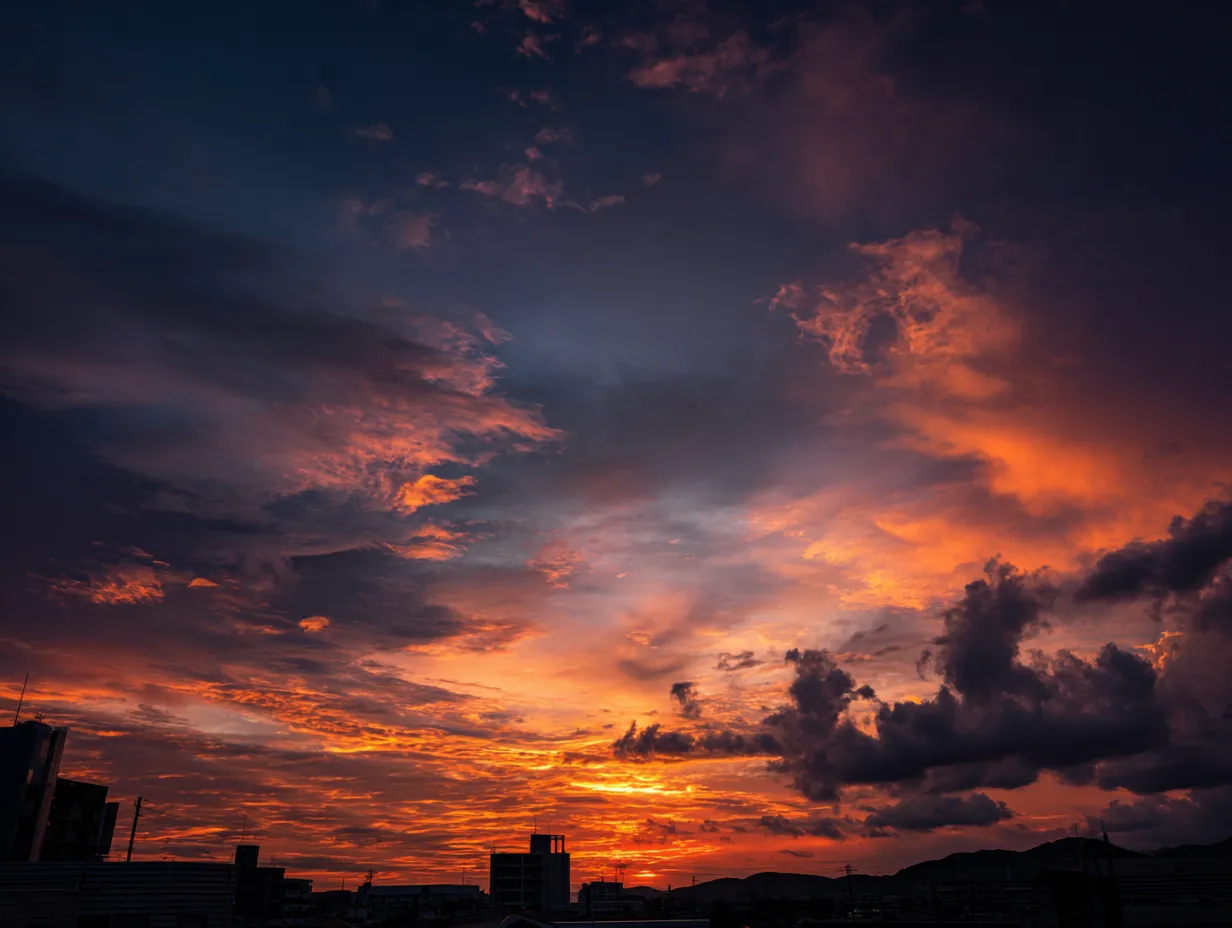 エモい空と紫色の夕焼け雲｜紫から赤へと変わる雲が印象的なエモい空のシーンです。都市のビル群とのコントラストが都会的でありながら幻想的な雰囲気を漂わせます。デザイン背景や表紙素材におすすめです。