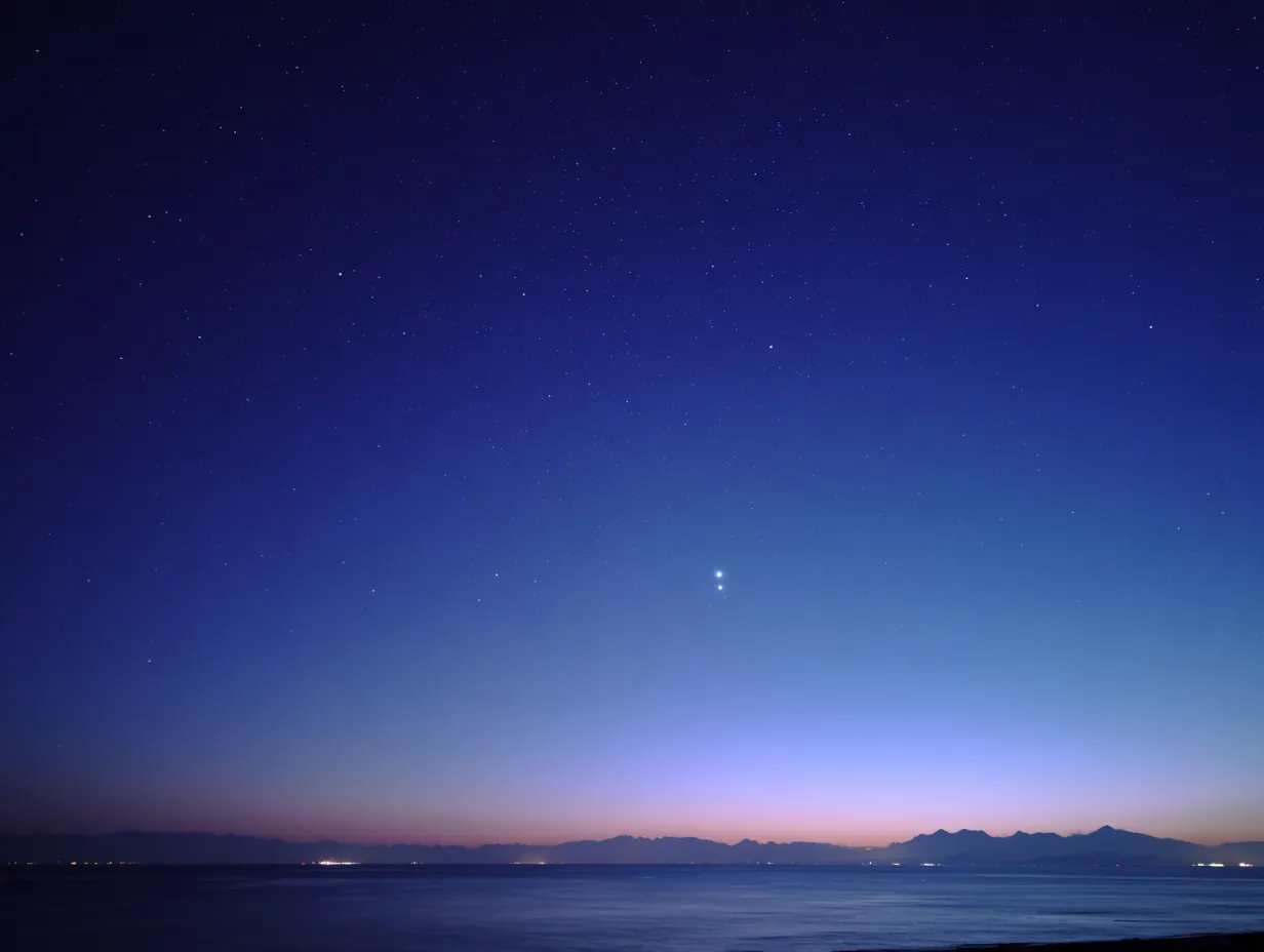 エモい空と静かな星明かり｜海と山の稜線に浮かぶ星々が美しいエモい空の素材です。水平線に淡い光が広がり、静けさと広がりを兼ね備えた幻想的なシーンです。癒しや自然をテーマにしたビジュアルに適しています。