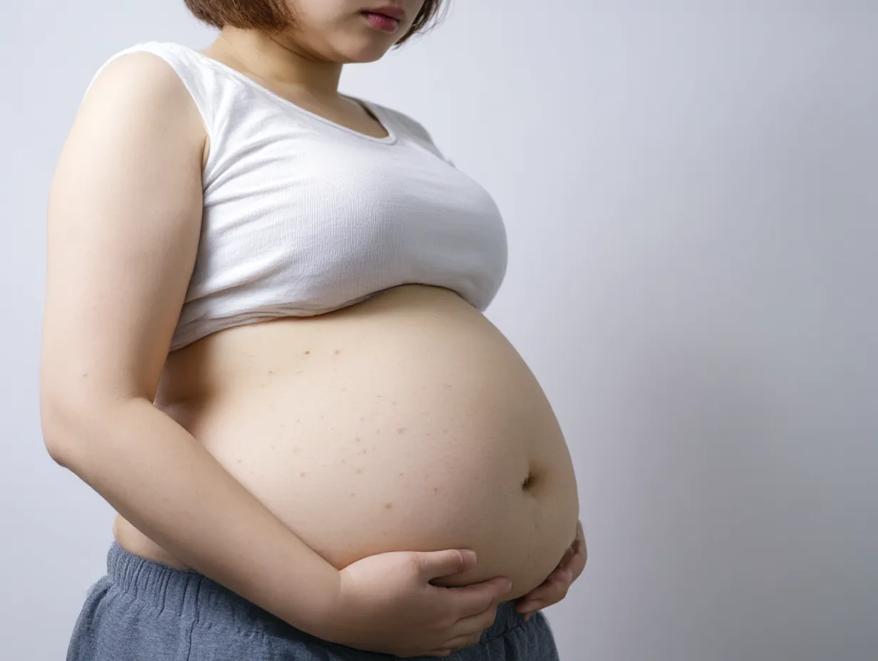 肥満の女性と太ったおなか｜女性の太ったおなかを抱える仕草が強調され、肥満を象徴的に表現。柔らかな丸みと肌の陰影が調和し、温かさと重みを同時に感じさせる構図が印象的に仕上がっている。