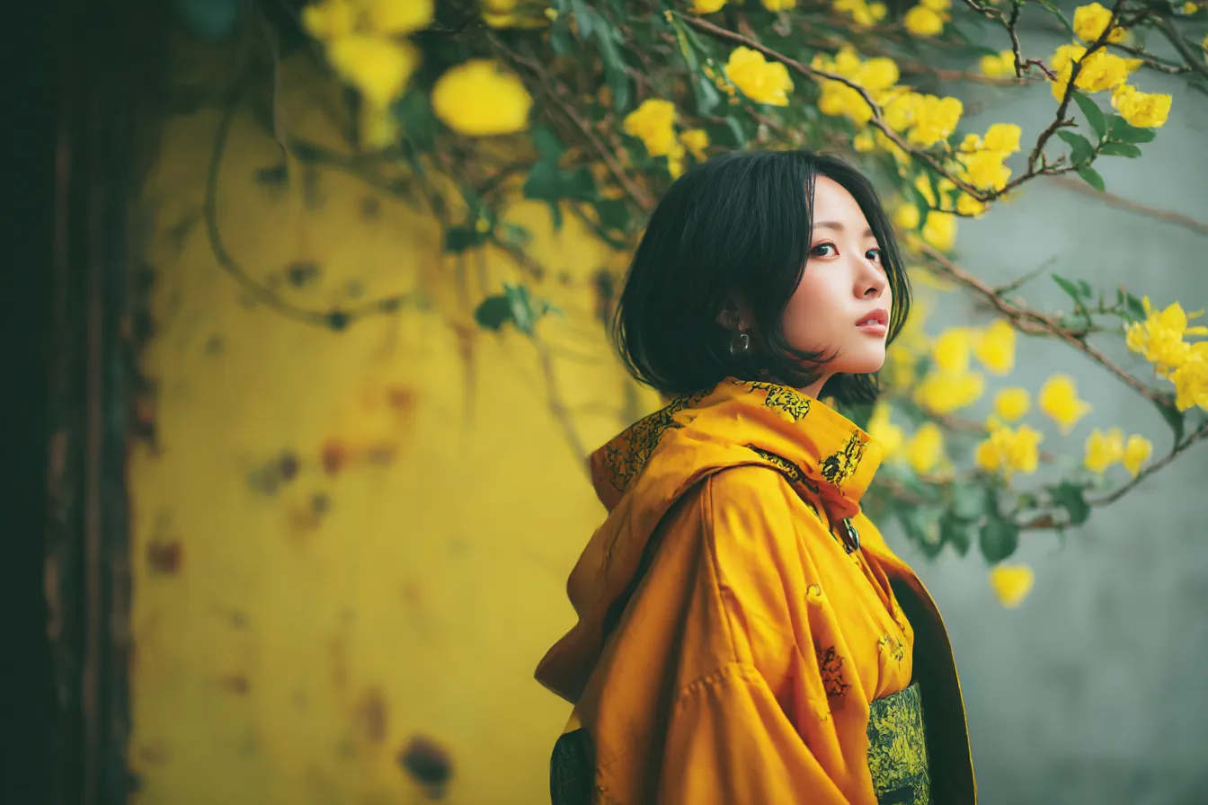 黄色背景に花と女性の横顔｜花々が柔らかく彩る黄色背景に視線を向ける女性の横顔が映え、ナチュラルな明るさと詩的な印象が融合した構成になっている。