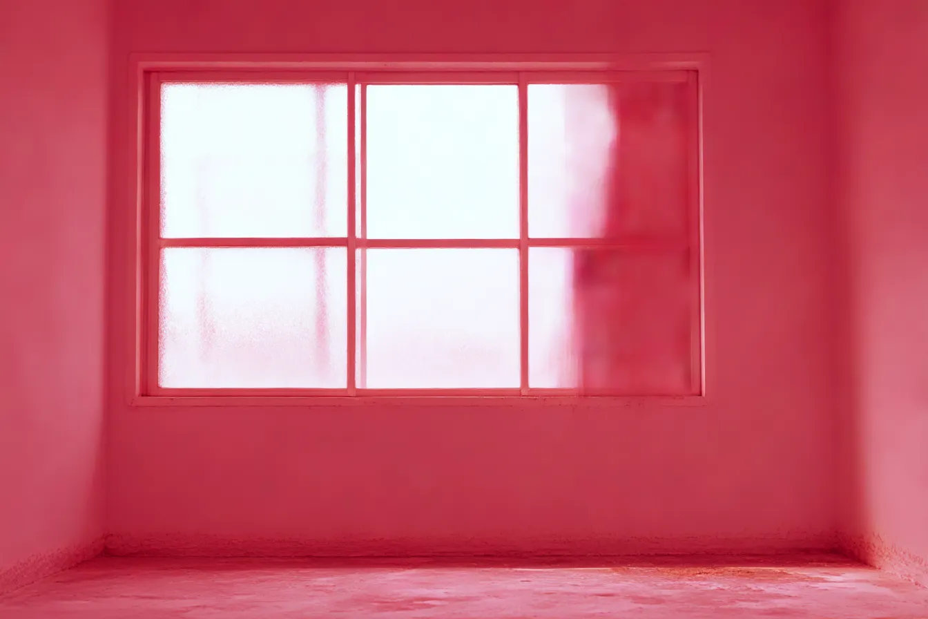ピンク背景の曇り窓インテリア｜柔らかく光を通す曇りガラスの窓が中心。ピンク背景が全体に染み込み、無機質な空間に幻想的なあたたかみと抽象性を加えている。