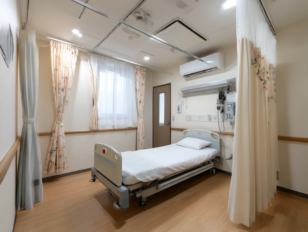 清潔な個室病室の入院患者写真｜カーテンと床の柔らかい色合いが安心感を与える個室の入院患者写真。すっきりとした構図と照明が清潔で落ち着いた療養空間を印象づける。