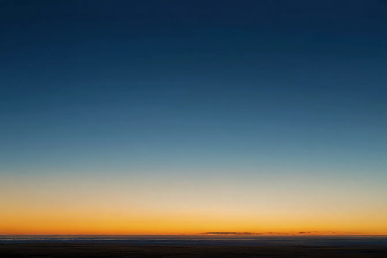 穏やかな海のグラデーション背景｜夜明けの空と海の「グラデーション」が広がり、心地よい安らぎを与える背景。空の色合いが徐々に深みを増し、視覚的に温かさと落ち着きのある空間を提供する。自然の美しさが感じられるシンプルな背景素材。