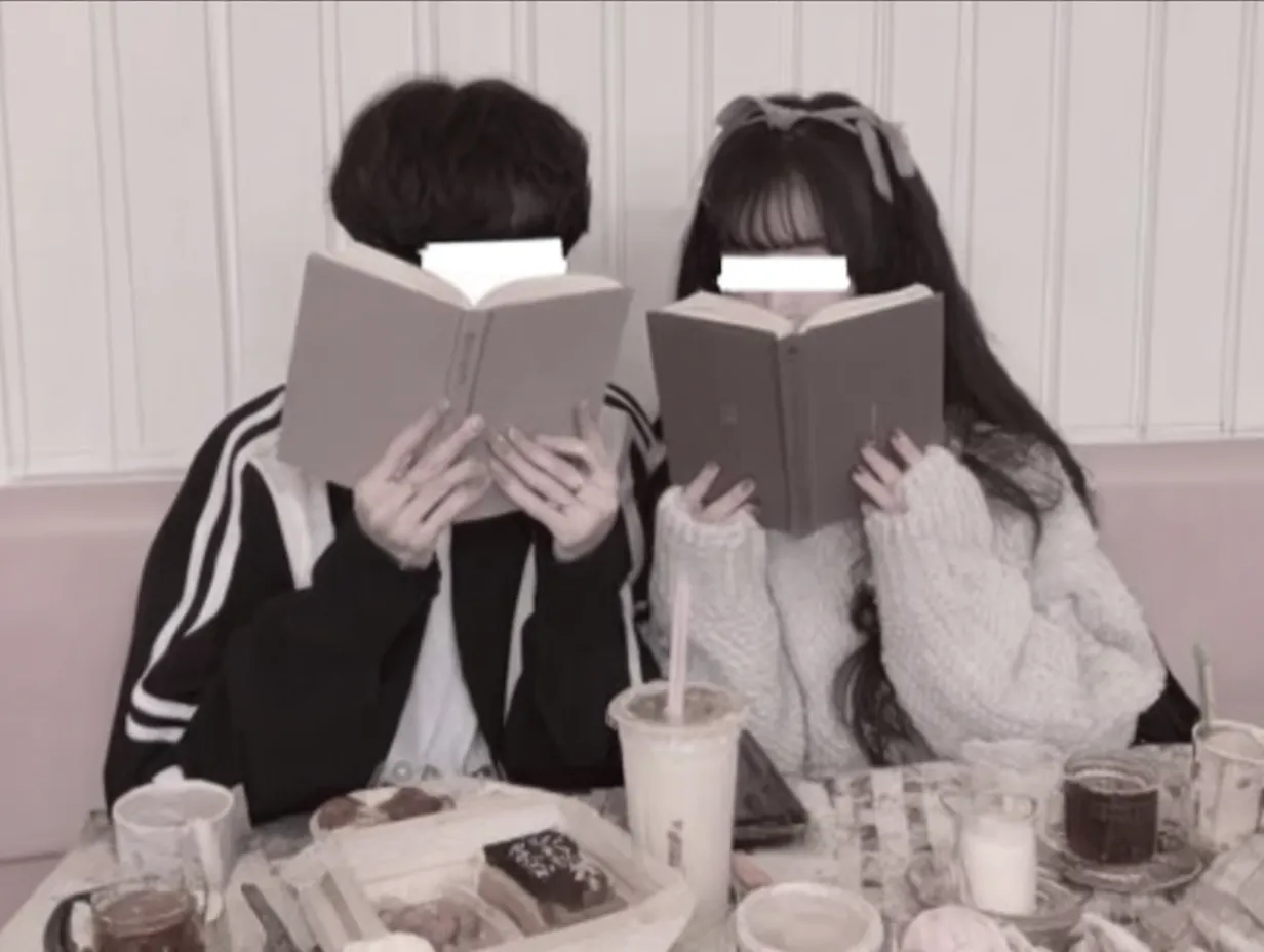 韓国風ペア画読書カフェの午後｜本を顔に隠す遊び心と、カフェテーブルに広がるドリンクやスイーツの彩りが特徴。韓国風ペア画らしいデート感がやさしく溶け込んでいる。