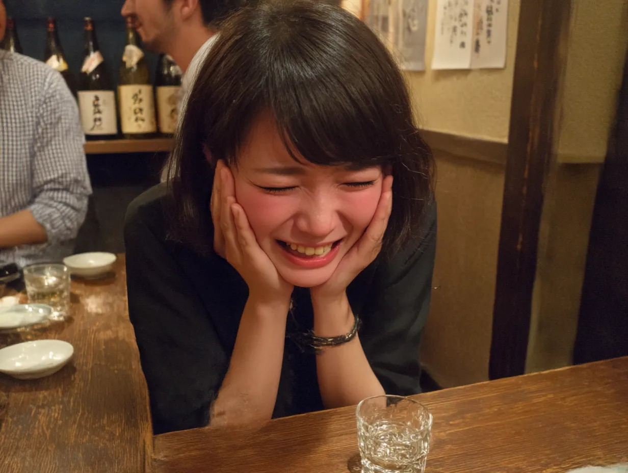 頬を赤らめた酔っ払い女性｜グラスを前に顔を手で覆いながら笑う表情が魅力的。酔っ払いならではの無防備さと幸福感を、親密な距離感で切り取った構図。