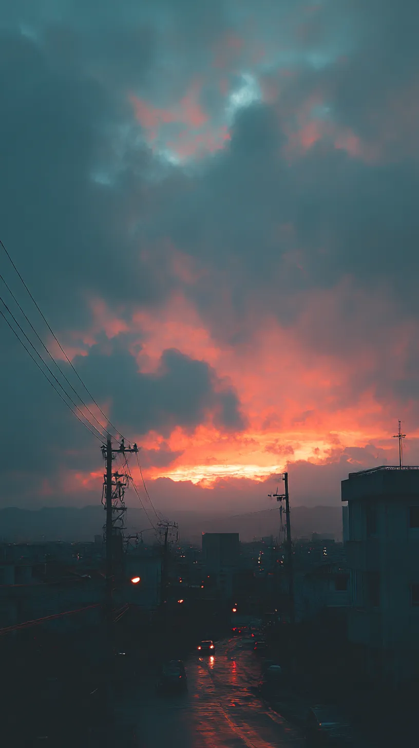 燃える雲間のエモいレトロ壁紙｜厚い雲の切れ間から差す夕焼けが、濃いオレンジに街を照らす。雨に濡れた道路が光を反射し、陰影に包まれた叙情を描くエモいレトロ壁紙。