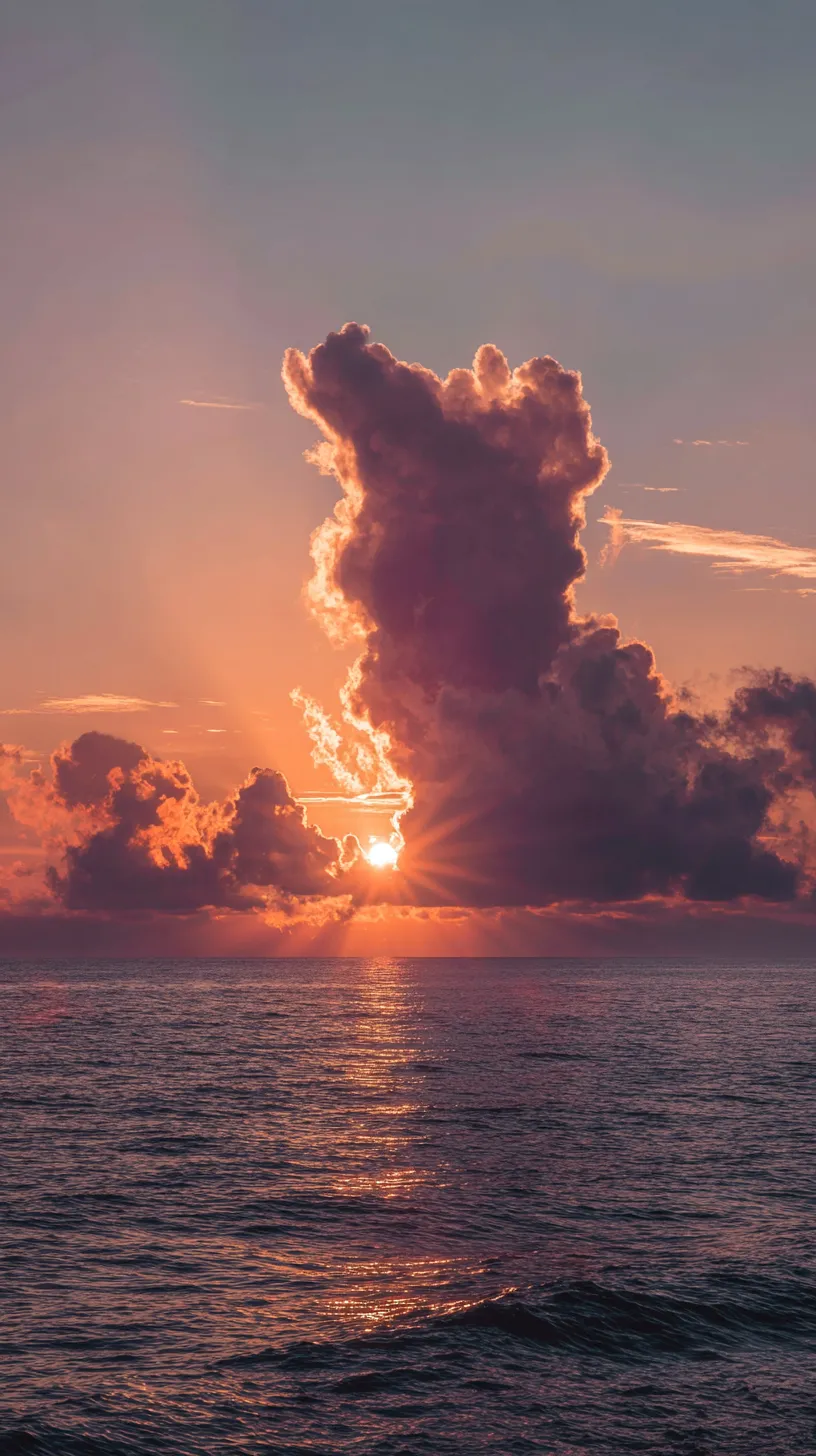 太陽と雲の壁紙｜雲の輪郭を縁取る光が強調され、海に伸びる光の道が印象的な太陽の壁紙。大きな雲のシルエットがドラマチックに空を彩る。