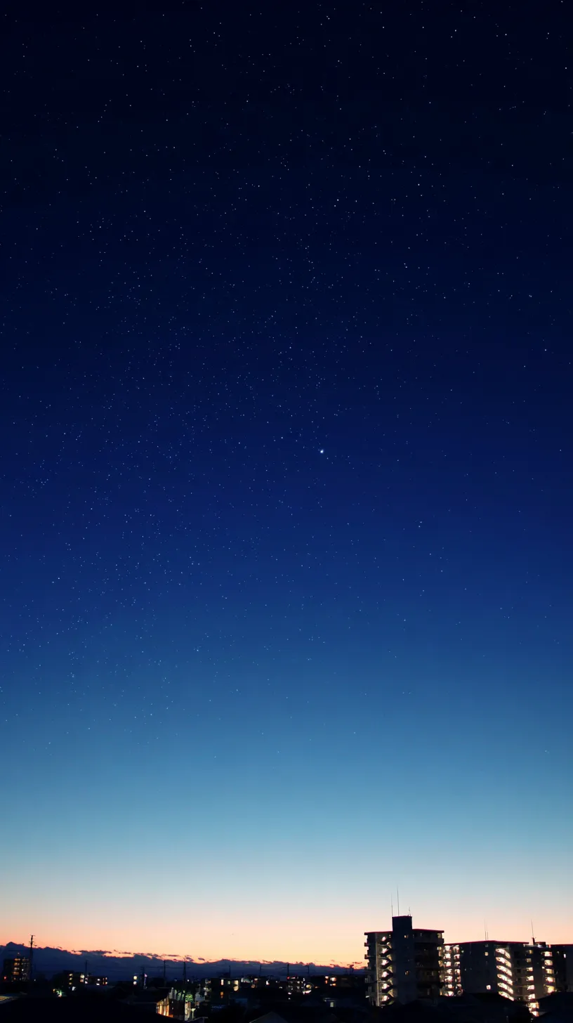 エモい夜景壁紙の星降る街｜深い青の空に散りばめられた星々と街明かりが溶け合うエモい夜景壁紙。夜明け前の静寂を背景に、都市の灯りが温かさを添え、広がる空間が余韻を残す構図となっている。